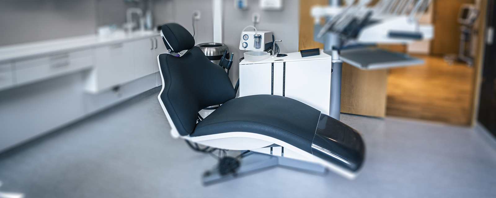 The image shows a dental chair in sharp focus, evoking a sense of fear of dental treatment.